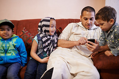 Buy stock photo Children, muslim father and mobile in home for playing games, bingo or watching videos with technology. Family, dad and kids or boy in portrait in living room for bonding, love and relax together