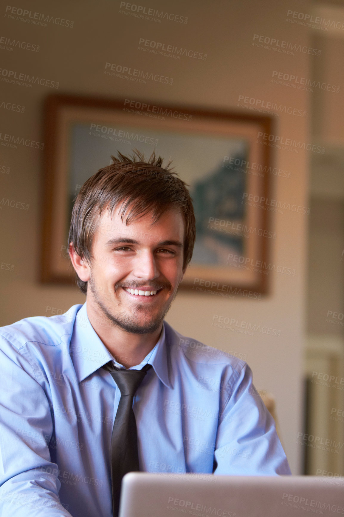 Buy stock photo Shot of a young businessman working on his laptop