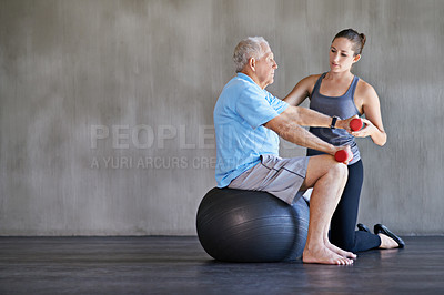 Buy stock photo Physical therapy, dumbbells and elderly man on ball for fitness, rehabilitation or exercise at gym on mockup. Senior person, weightlifting and personal trainer help for body health or physiotherapy