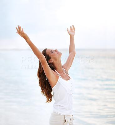 Buy stock photo Shot of a beautiful young woman with her arms raised to the sky