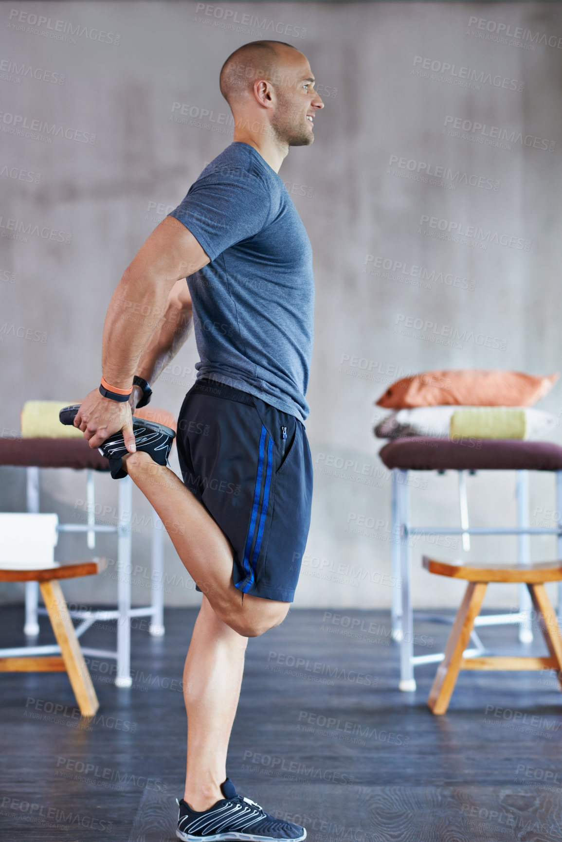 Buy stock photo A cropped shot of a handsome trainer stretching before a workout session