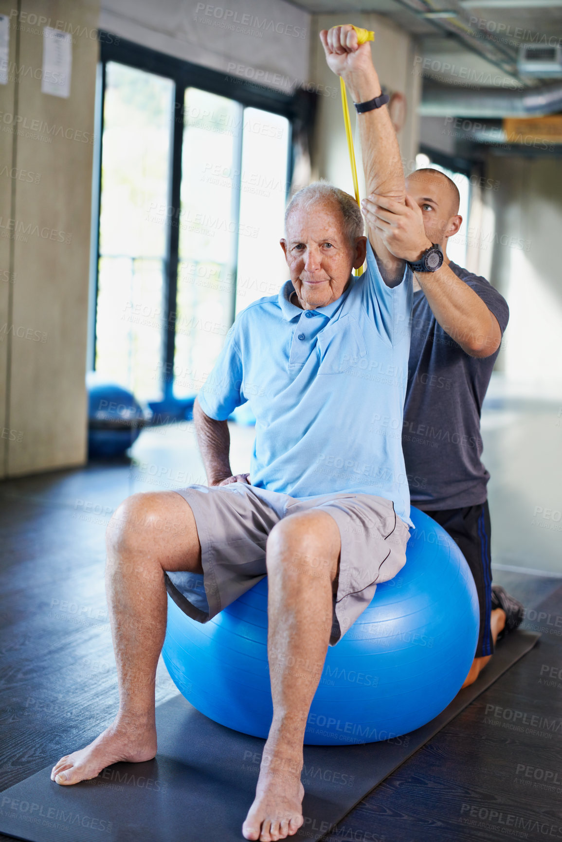 Buy stock photo Physiotherapist, helping and senior man with elastic, training and elderly support for care. Men, gym and exercise for health, wellness and coaching with yoga ball for mature rehab and wellbeing