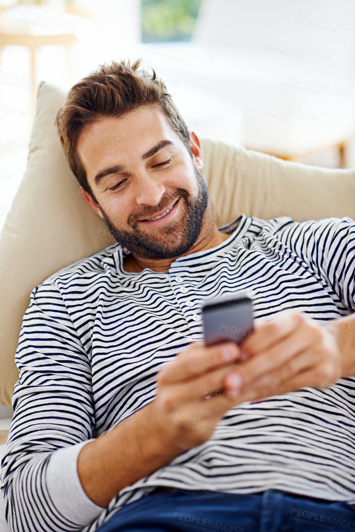 Buy stock photo Man, happy and cellphone on couch in living room for for communication, social media and or texting. Smartphone, smile and male person for internet browsing, notification or online chat on weekend