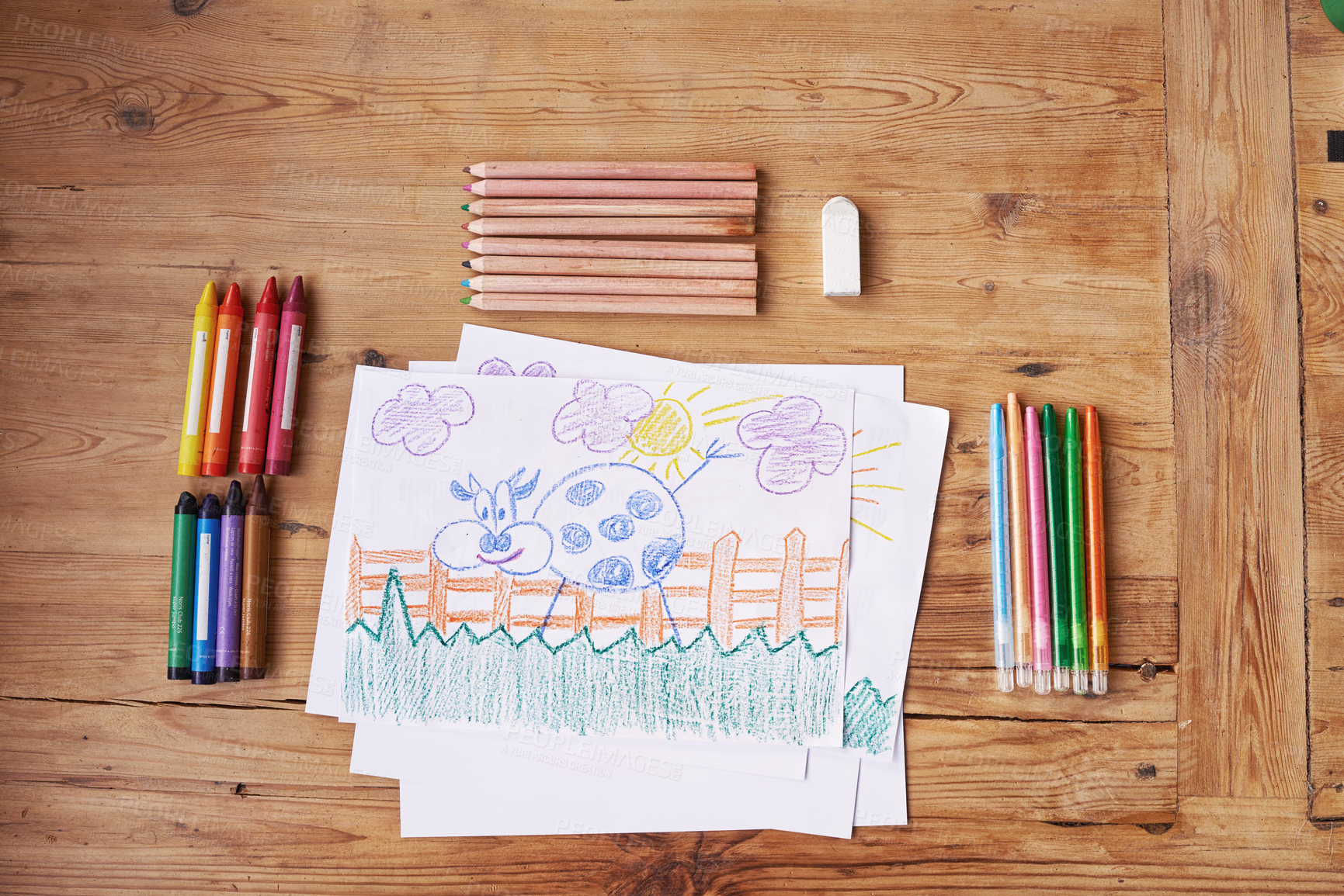 Buy stock photo Shot of a drawing with painting supplies and pencils on a wooden table