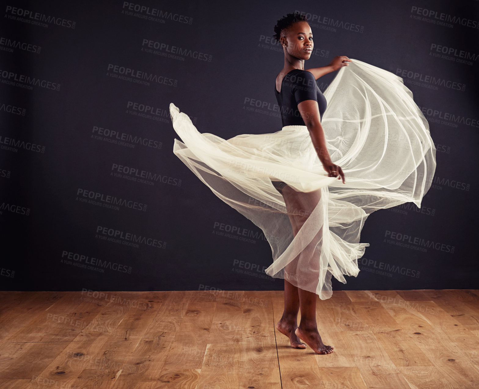Buy stock photo Young female contemporary dancer using a soft white white skirt for dramatic effect