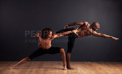 Buy stock photo Two male contemporary dancers performing a dramatic pose in front of a dark background