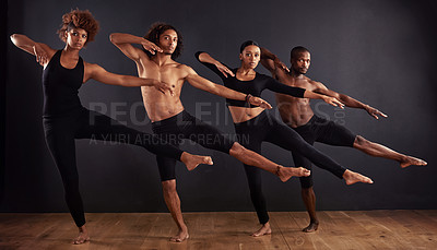 Buy stock photo A group of dancers performing a dramatic pose in front of a dark background