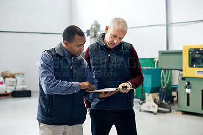 Buy stock photo Shot of two factory managers doing a warehouse inspection