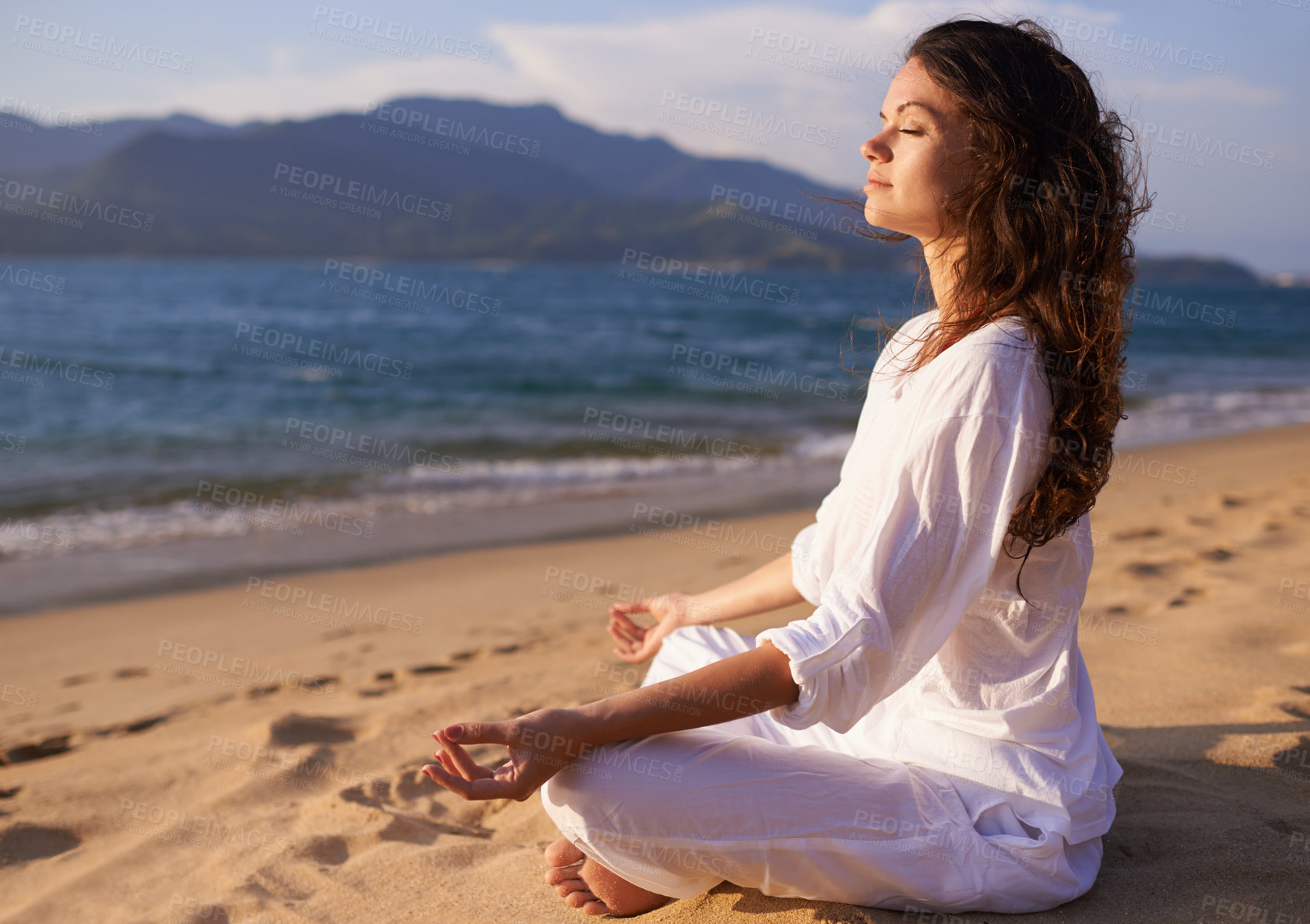 Buy stock photo Shot of a young woman doing yoga at the beach