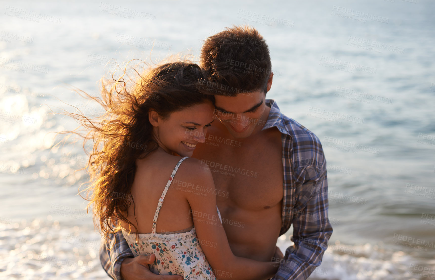 Buy stock photo Sunshine, couple hug on beach and ocean, travel for anniversary or date with bonding, love and support. Affection, peace and fresh air in nature, people outdoor with trust and care in relationship