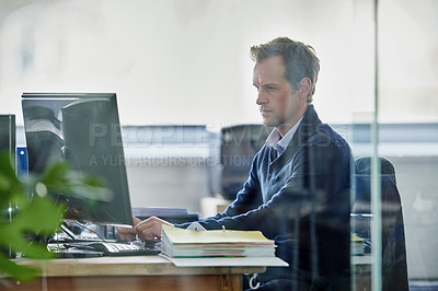 Buy stock photo Cropped shot of a handsome young designer working on a pc