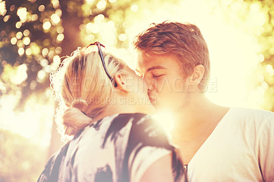 Buy stock photo Love, kiss and dating with a couple in the forest together for hiking, romance or bonding at sunset. Summer flare, nature park or garden with a happy man and woman in a garden for travel or freedom