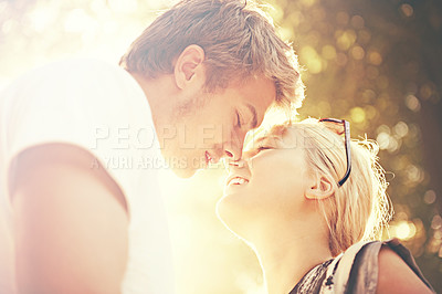 Buy stock photo Love, kiss and flare with a couple in the forest together for hiking, romance or bonding at sunset. Summer dating, nature park or garden with a happy man and woman in a garden for travel or freedom