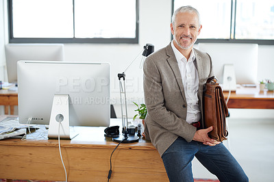 Buy stock photo Portrait of a casually-dressed mature businessman sitting on his desk in an office