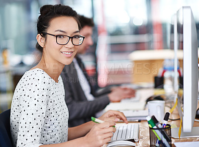 Buy stock photo Shot of a young office worker sitting at her workstation in an office