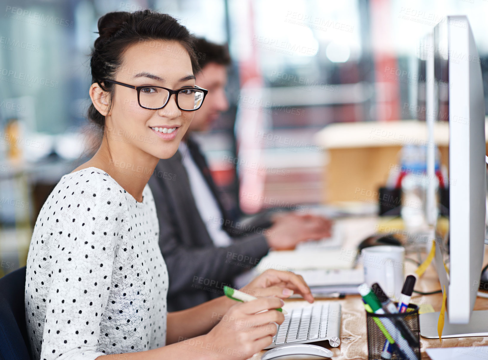 Buy stock photo Shot of a young office worker sitting at her workstation in an office