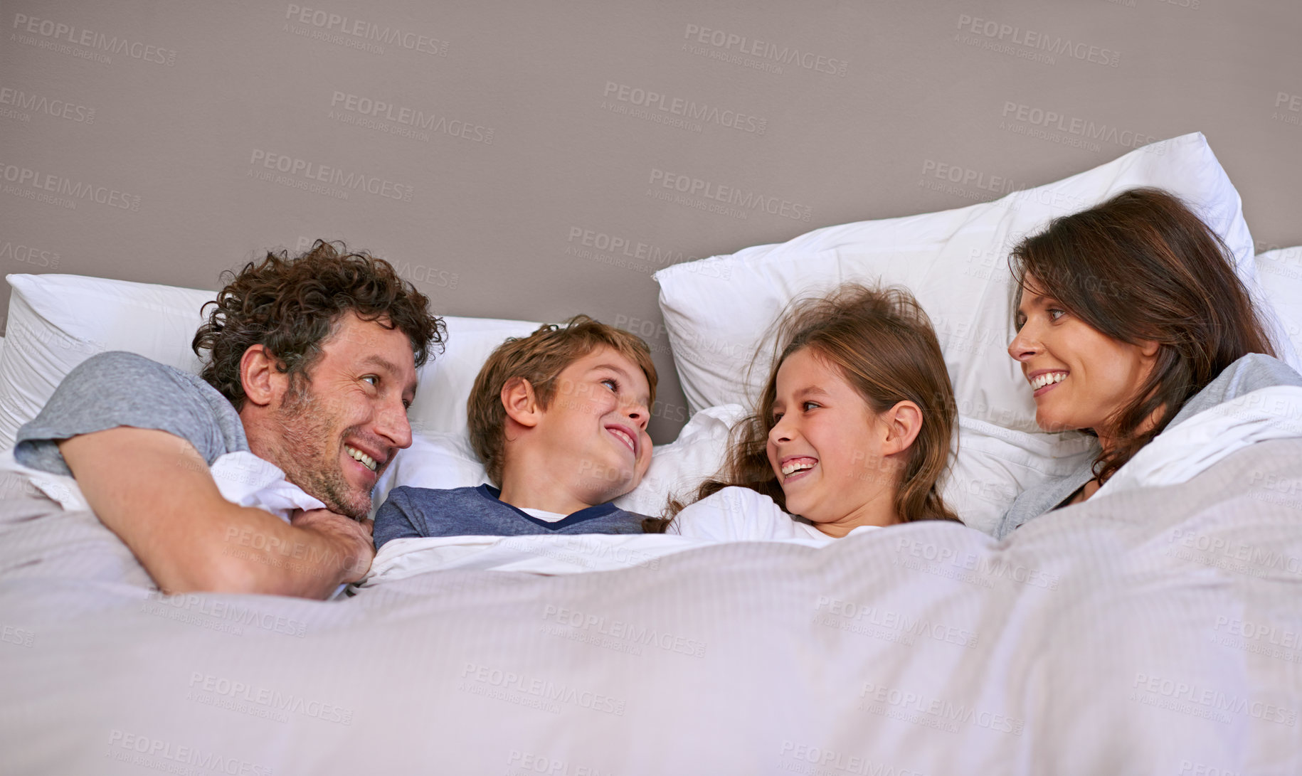 Buy stock photo Bedroom, family and parents with children, relax and morning with smile, funny and peaceful. Mother, father and bed with kids and siblings with vacation and weekend break with humor, calm or laughing