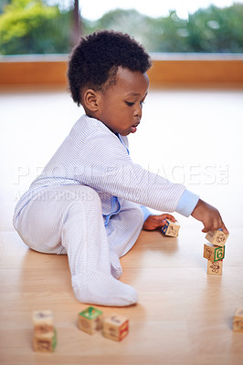Buy stock photo Black baby, playing and wooden blocks in house on floor for child development, growth and motor skills. African kid, playtime and building piece in home in living room for fun, childhood and learning