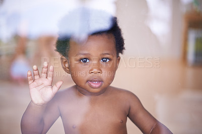 Buy stock photo Baby, portrait and smile behind window, natural and child development for toddler growth in family home. Children, sensory education and touch with hand on glass, curious play with young African boy