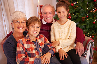 Buy stock photo Christmas, senior couple and couch with grandchildren, happiness and relax for festive season at home. Xmas, love and elderly man with mature woman, grandkids or happy with smile, content or portrait