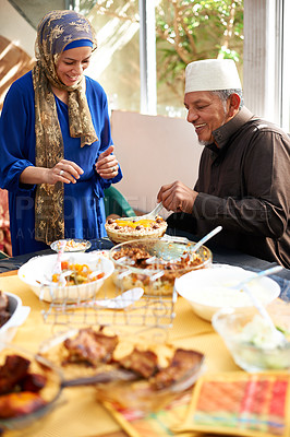 Buy stock photo Eid, holiday and family with food for muslim celebration with man giving woman a plate at table. Home, buffet or hungry for dish of dessert or excited for meat on festival vacation for Islam religion
