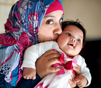 Buy stock photo Happy, muslim and mom kiss baby in portrait at home with love and care for family in Saudi Arabia. Infant, child and Arabic mother relax in house with support and kindness of mama for kid in embrace