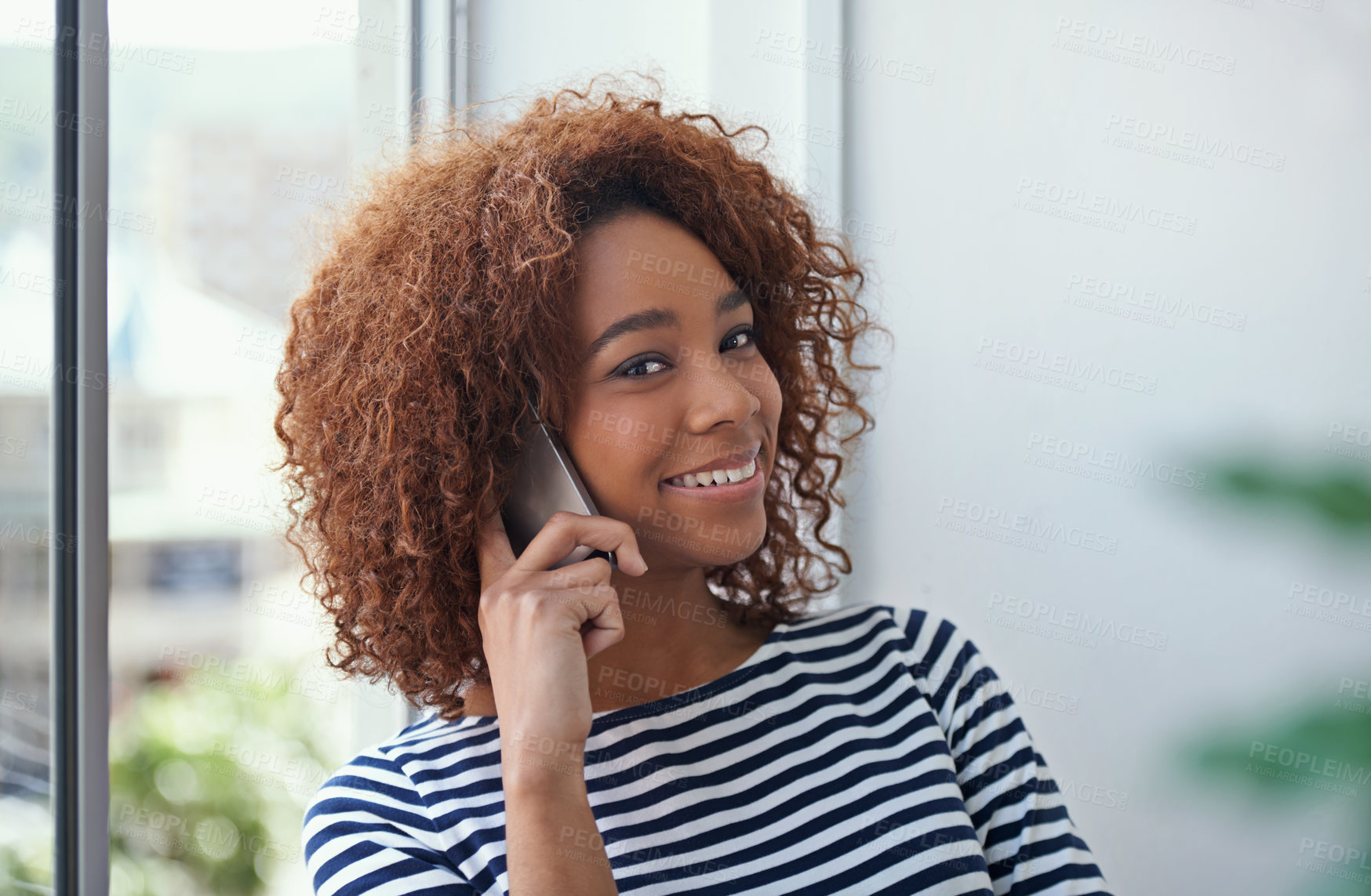 Buy stock photo Shot of a young woman talking on the phone in an office