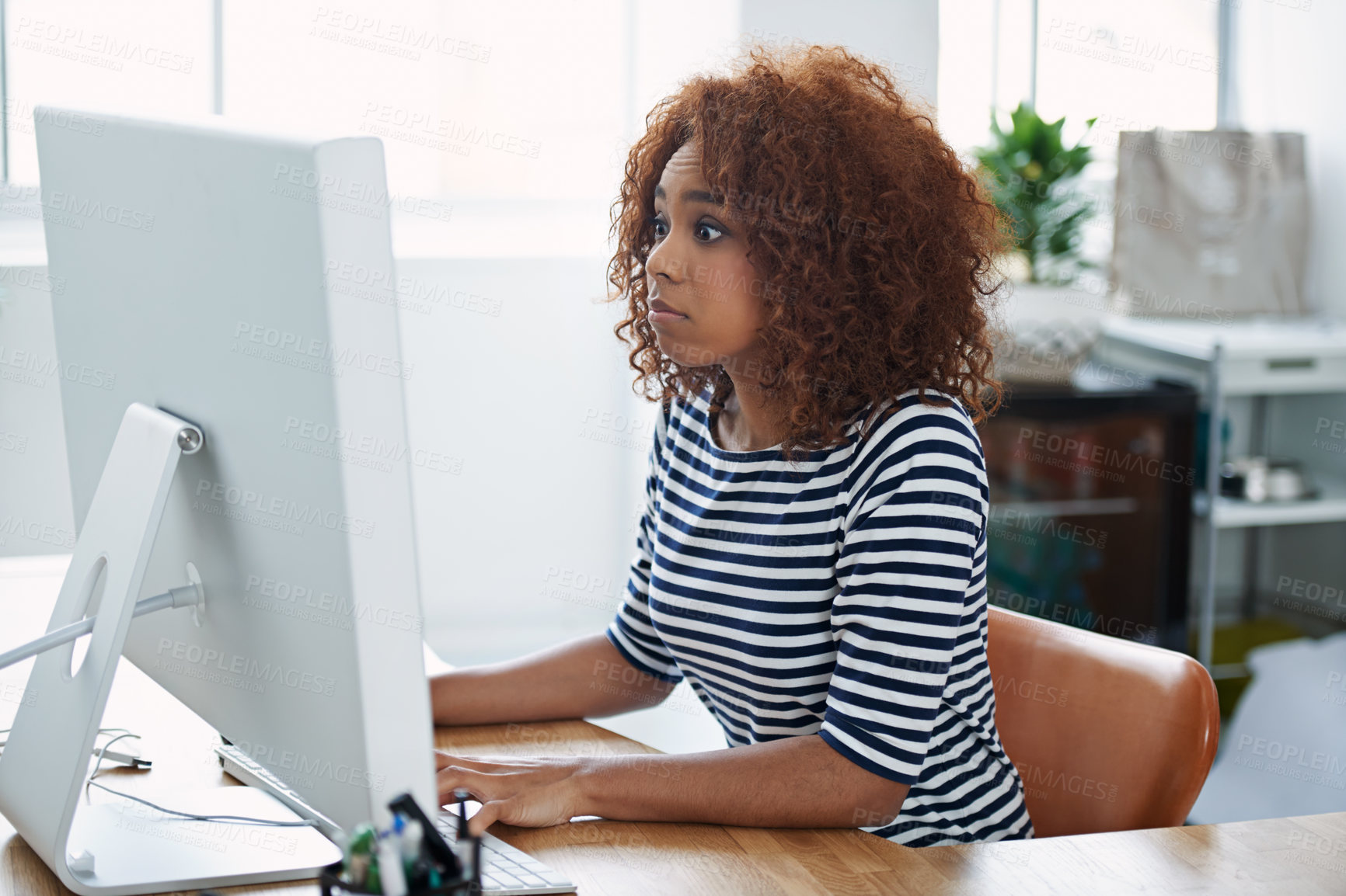 Buy stock photo Shot of a young woman at work on a computer in an office