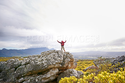 Buy stock photo Shot of a man at the top of a rugged mountain