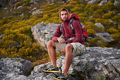 Buy stock photo Man, mountain and hiking in nature for rest and fitness for wellness and exercise for training and adventure in environment. Young person, sitting with backpack on rock for workout and trekking
