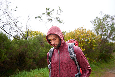 Buy stock photo Nature, walking and man with backpack in rain, hoodie and travel on landscape, fresh air and wellness. Forest, trekking or hiking of male person for exercise, health or fitness for holiday and trip