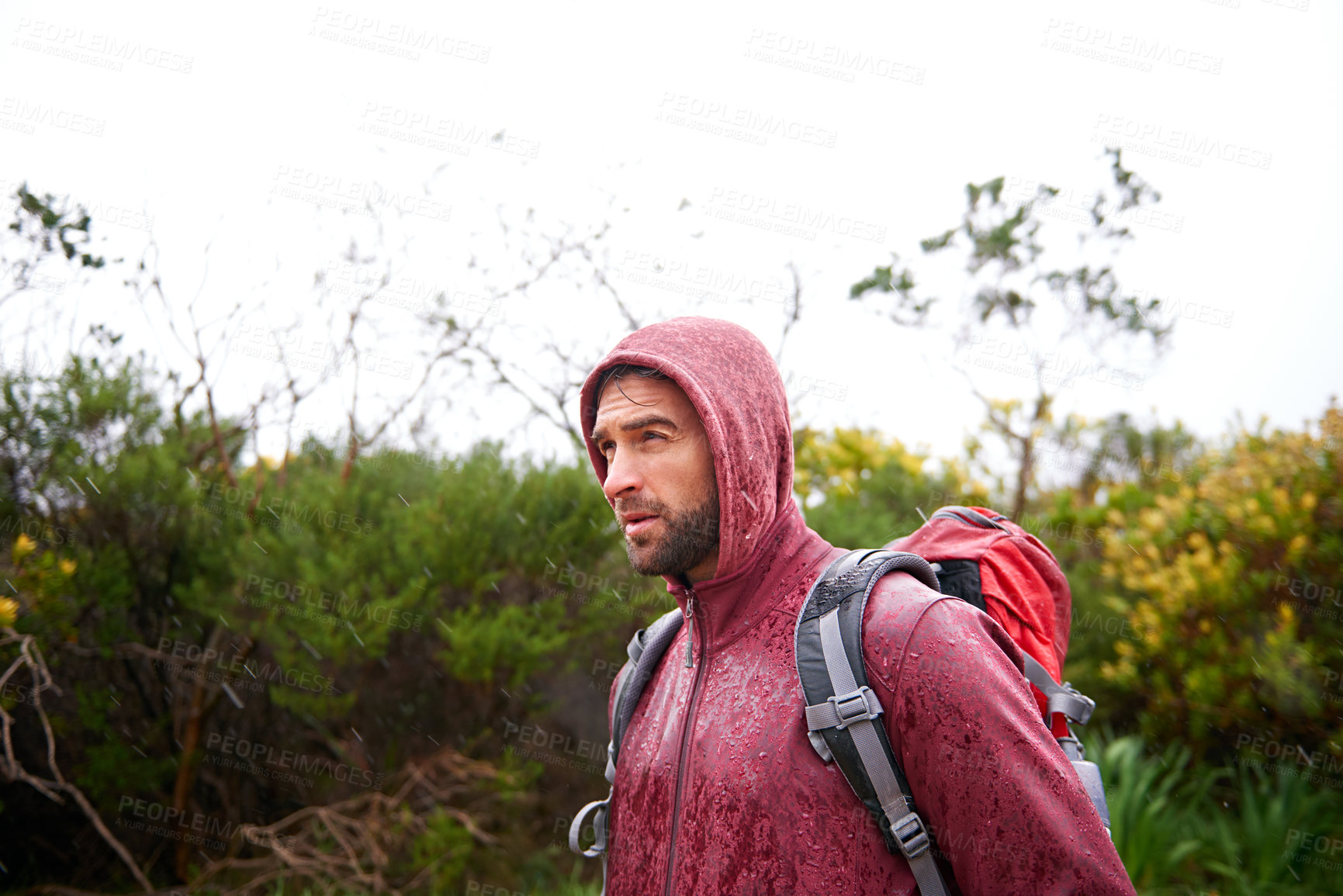 Buy stock photo Extreme, hiking and man in rain, walking and holiday for survival adventure, outdoor and trekking. Water, traveller and male person with backpack in tough environment, rough and destination of Europe