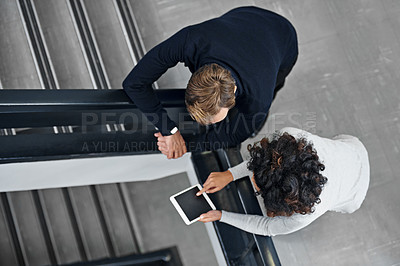 Buy stock photo Shot of colleagues on the staircase using a digital tablet