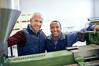 Buy stock photo Shot of two men working over factory machinery