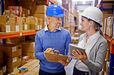 Buy stock photo Shot of two managers looking at stock in a large warehouse