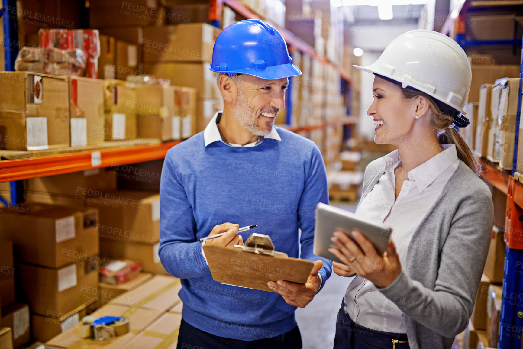 Buy stock photo Shot of two managers looking at stock in a large warehouse