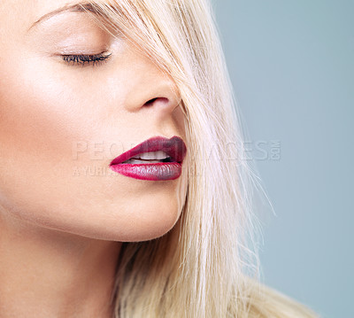 Buy stock photo Closeup studio shot of a young blonde woman with vivid red lipstick against a gray background