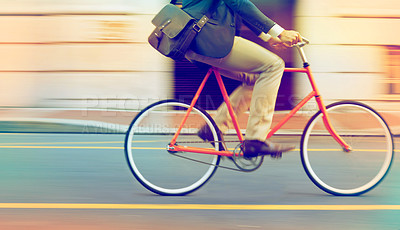 Buy stock photo Cropped shot of a man riding his bicycle through the city
