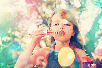Buy stock photo Portrait, nature and kid blowing bubbles at park, relax and girl having fun outdoor. Toy, garden and face of child with soap on summer vacation for recreation, leisure and playing game in low angle