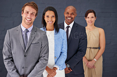 Buy stock photo Portrait of a group of confident businesspeople standing against a gray background