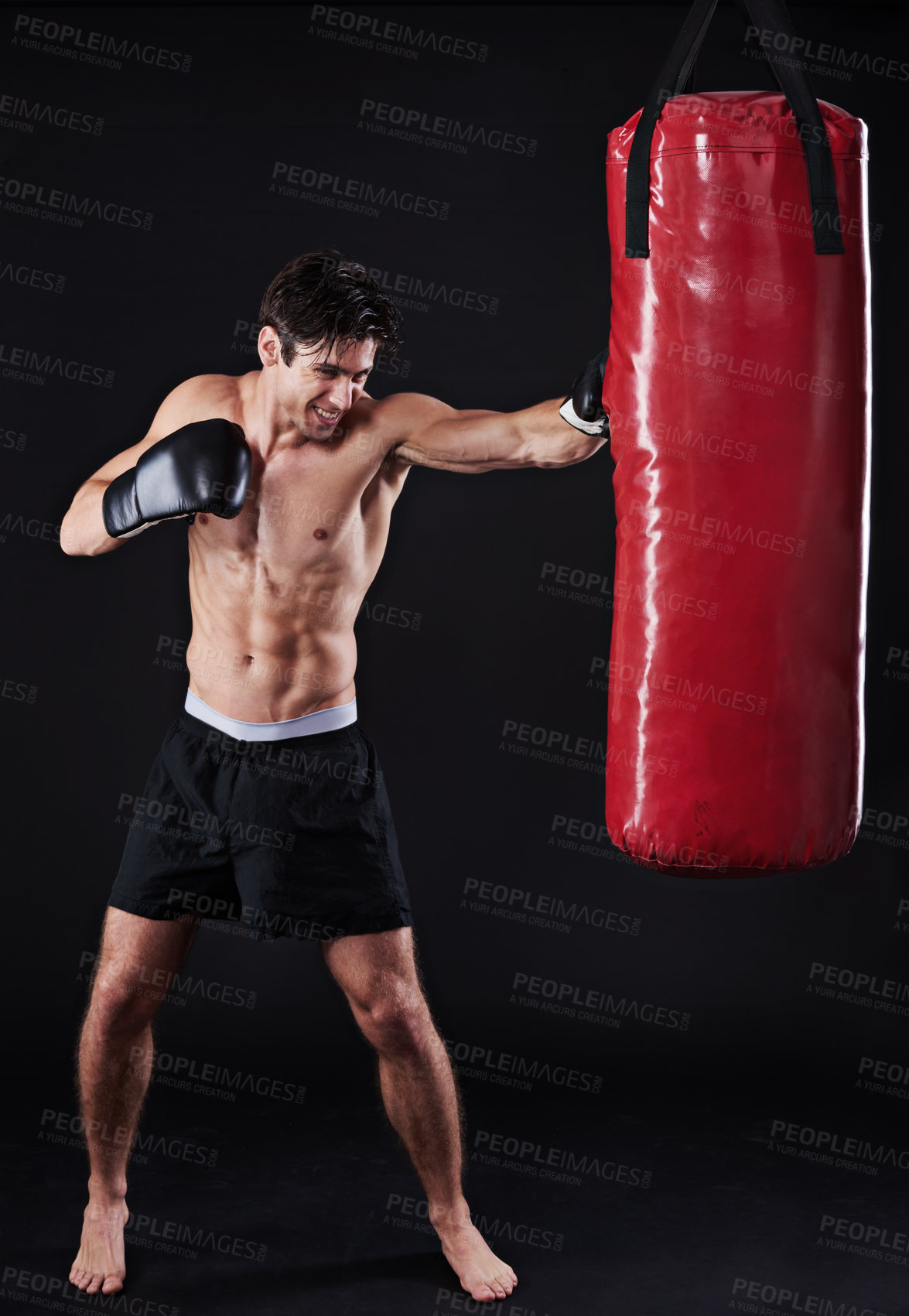 Buy stock photo Boxer, man and punch in studio with boxing bag for workout, exercise or fight competition with dark background. Sports, gloves and serious male athlete for confidence, martial arts and fitness