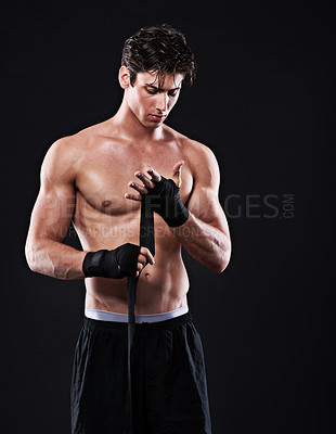 Buy stock photo Wrapping, hands and man in martial arts for boxing on black background in studio with preparation. Tape, fist and ready to start training as boxer in mma competition or gym with fitness mockup space