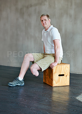 Buy stock photo Man, portrait and amputee with commitment at gym for motivation, health and wellness. Active person with a disability or leg condition sitting on box in fitness for workout exercise on mockup space