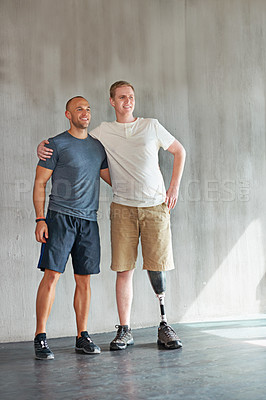 Buy stock photo Physiotherapist, man with a disability and prosthetic leg and hug in physiotherapy, studio and gym. Male people, trainer and amputee for wellness, fitness and exercise in rehabilitation center