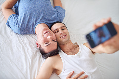 Buy stock photo Phone screen, selfie and gay couple on bed with memory, love or top view bonding at home. LGBTQ, profile picture or people relax in bedroom with smartphone photo for social media, blog or post