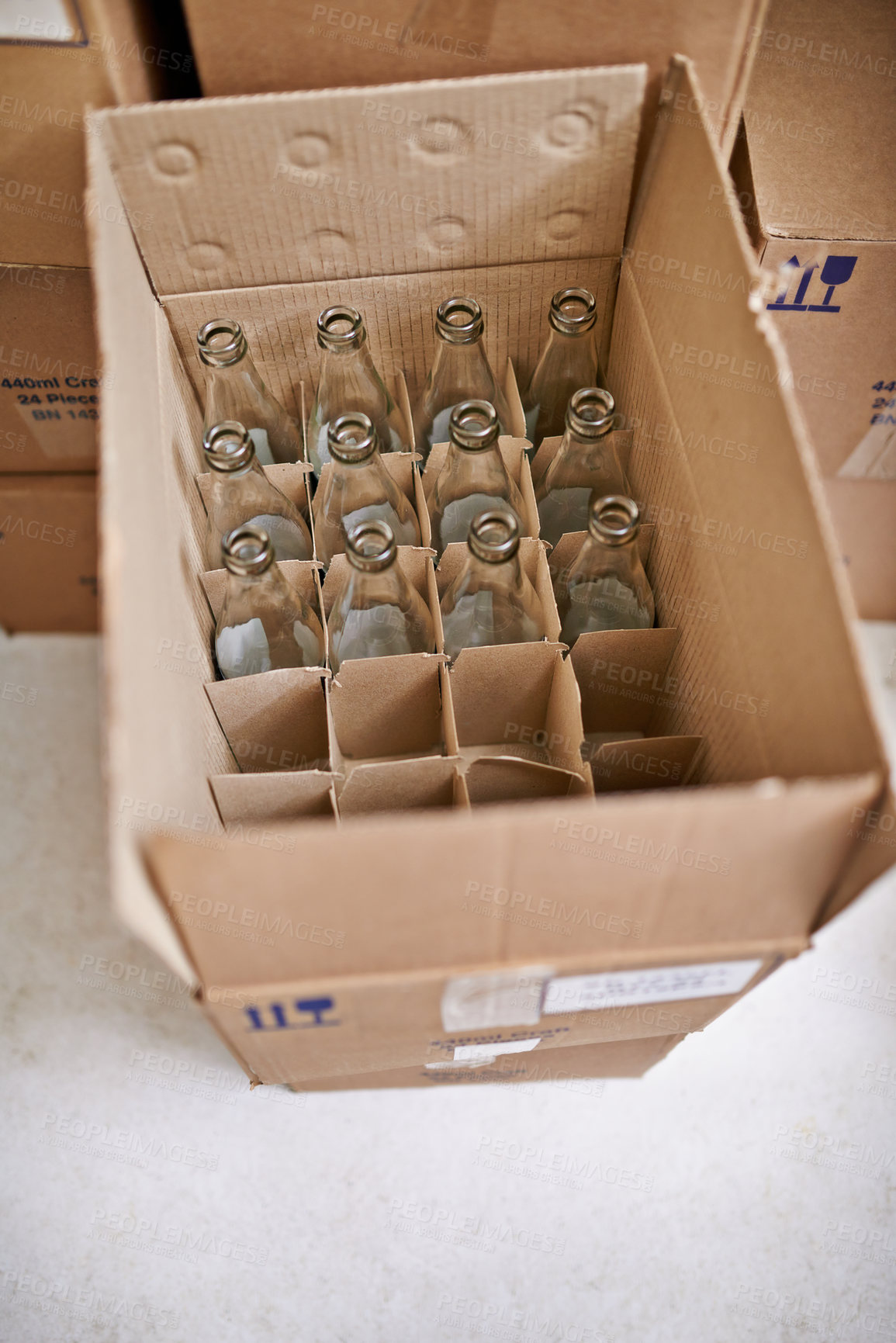 Buy stock photo Empty beer bottle, box and storage in factory on floor, above and container for supply chain, process or delivery. Cardboard package, glass and brewery for alcohol, cider or production in warehouse