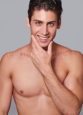 Buy stock photo Man, skincare and happy in studio portrait with hand on face for wellness by gray background. Person, model and facial dermatology for self care, shaving or transformation for glow, pride or results