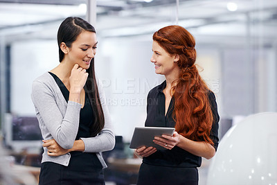 Buy stock photo Cropped shot of two female coworkers using a digital tablet