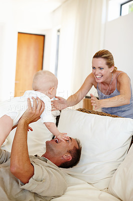 Buy stock photo Funny, happy family and play with baby on sofa in home for love, care or father bonding together with mother. Dad, kid and cute infant in living room for connection, smile or parents laugh with child