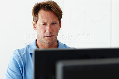Buy stock photo Shot of a mature man concentrating on his computer screen